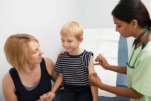 mother-supporting-son-receiving-injection
