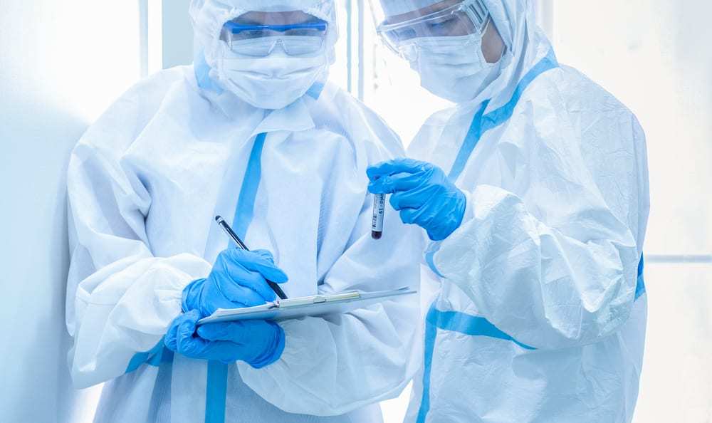 Two healthcare workers in personal protective suits