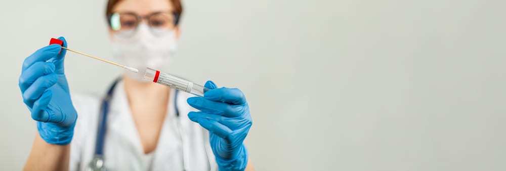 Female health care worker holding out a coronavirus test swab