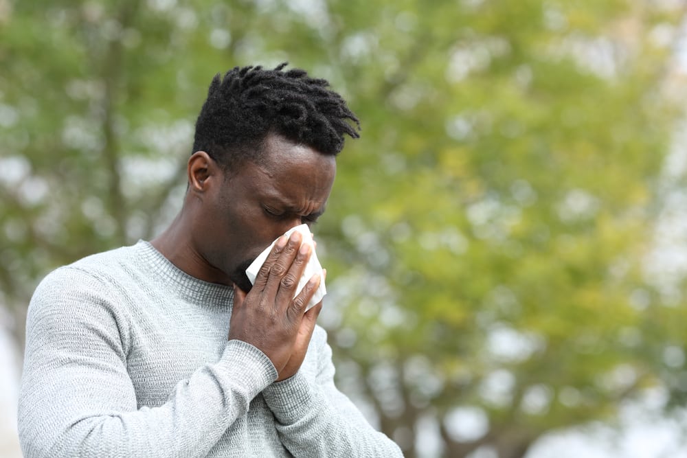 Close-up of man blowing nose outside