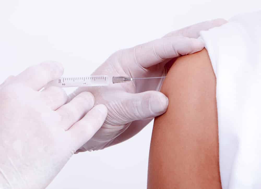 Close-up-of-gloved-hand-adminstering-vaccine