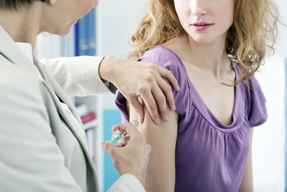 Close-up-of-young-woman-receiving-vaccination-in-arm