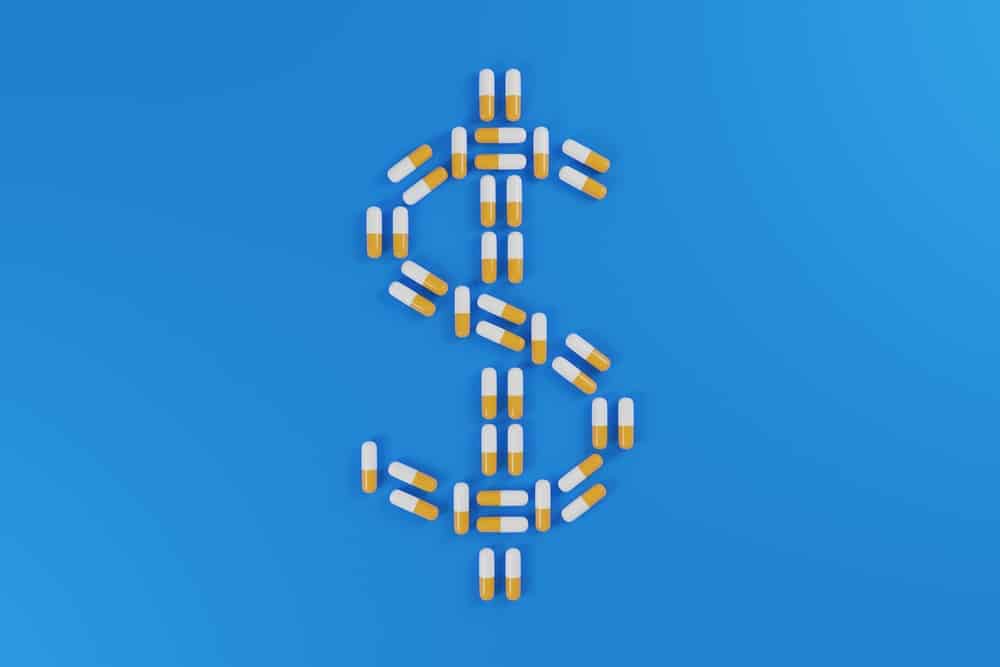 Yellow and white pills forming a dollar sign on a blue background