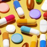 Colorful pills on yellow background