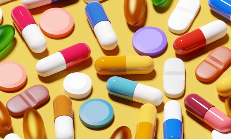 Colorful pills on yellow background