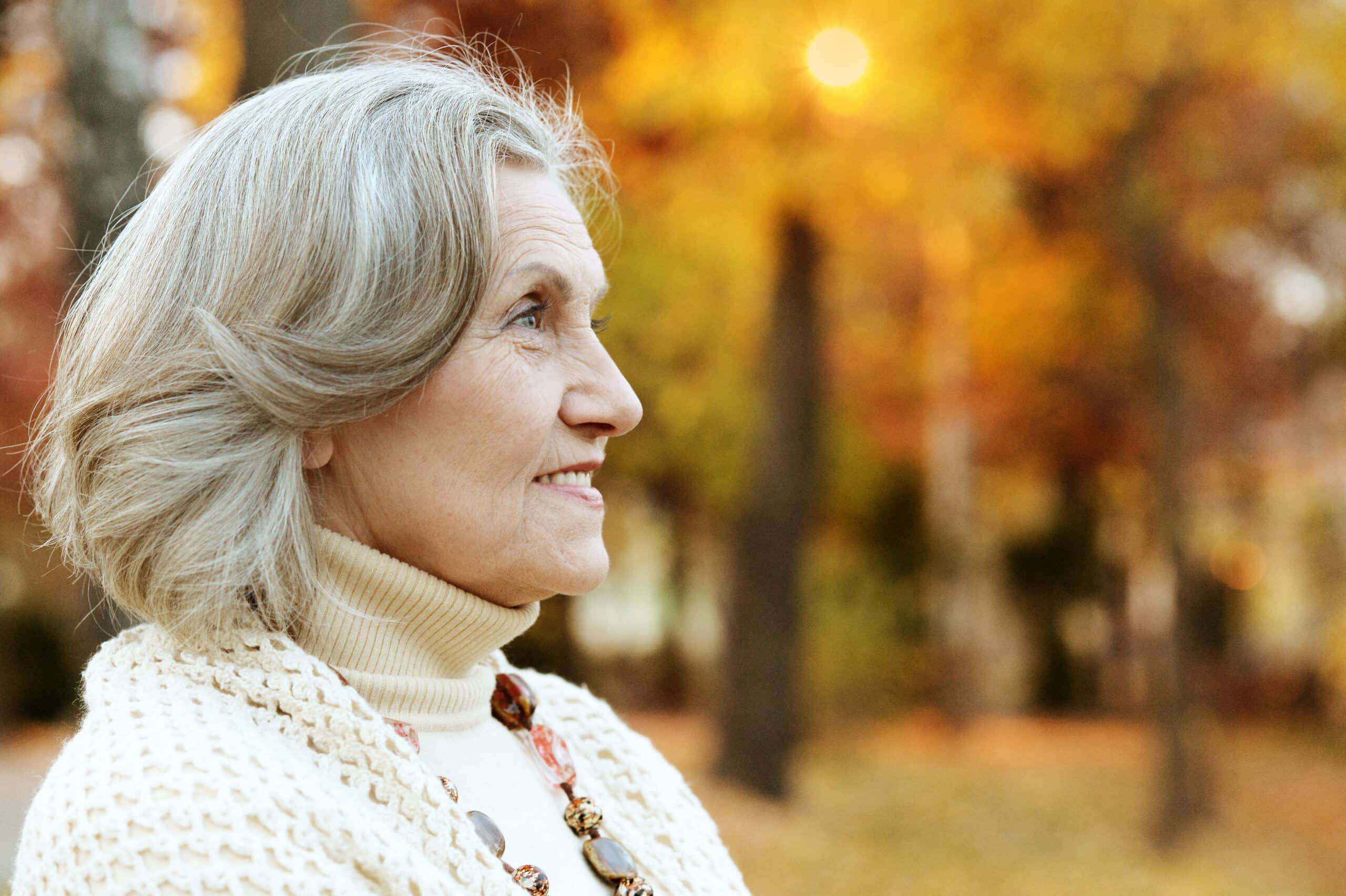 Smiling senior woman in park in fall