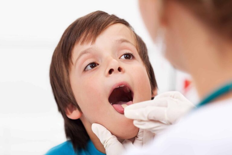 Doctor looking at throat of child to check for strep