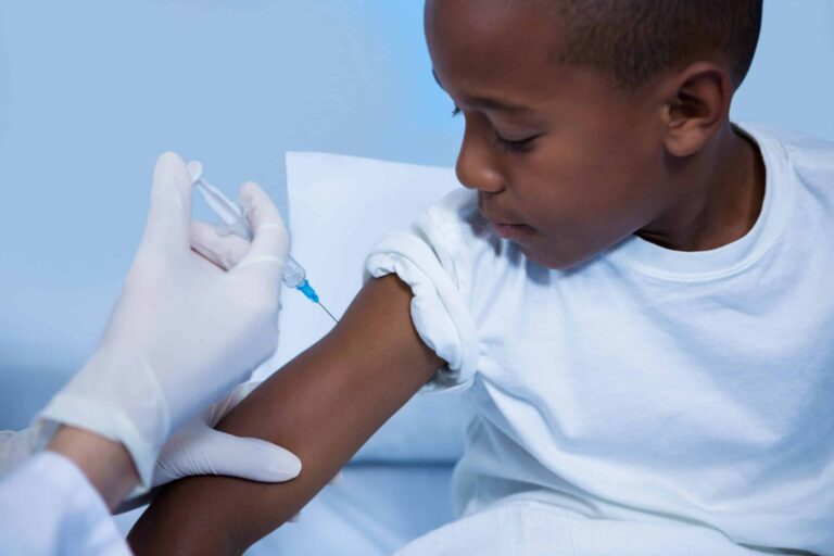 Healthcare professional giving a vaccine injection to young boy