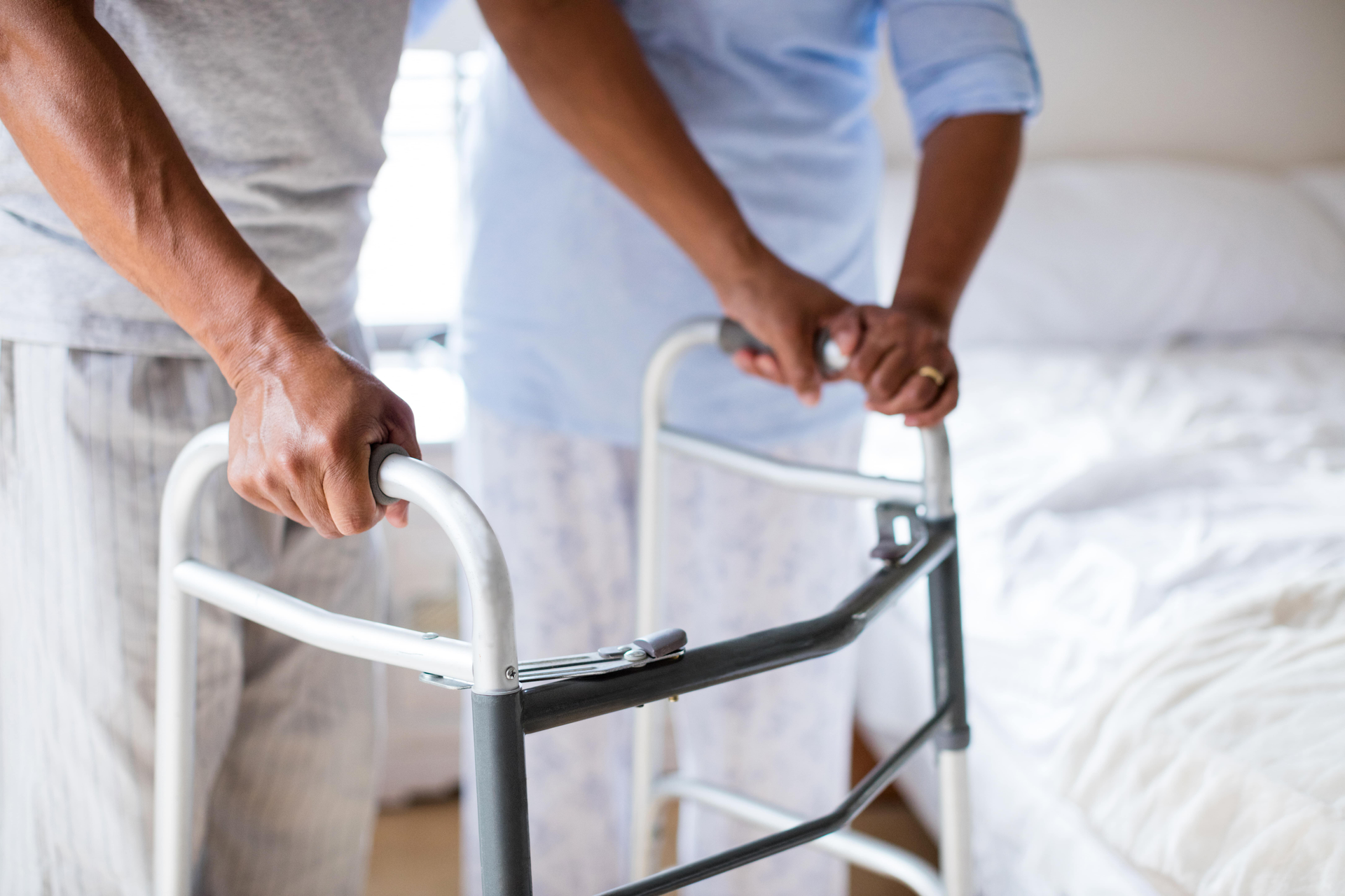 Close-up of nurse helping young man using walker