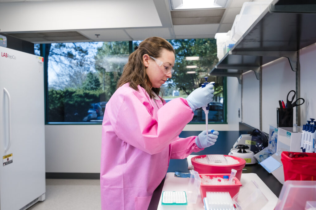 QPS Scientist at bench with pipette