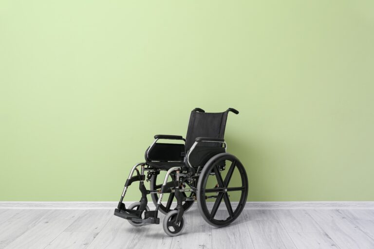 Wheelchair sitting alone, green wall