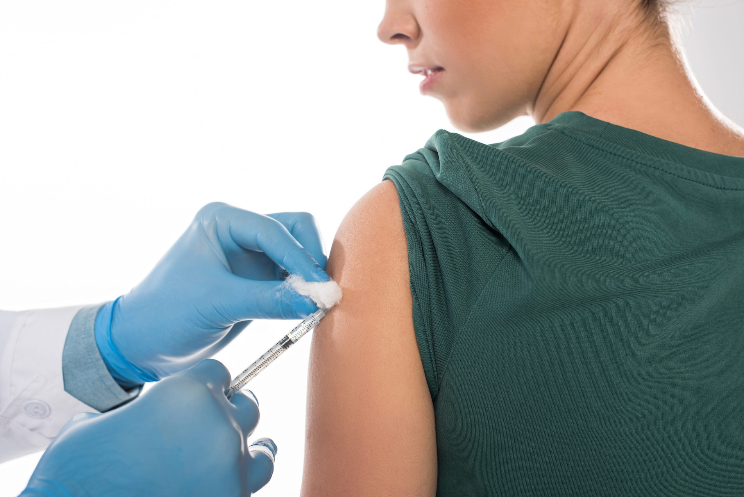 Healthcare professional administering vaccine to young woman