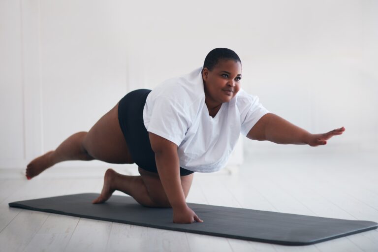 Smiling young woman practicing yoga