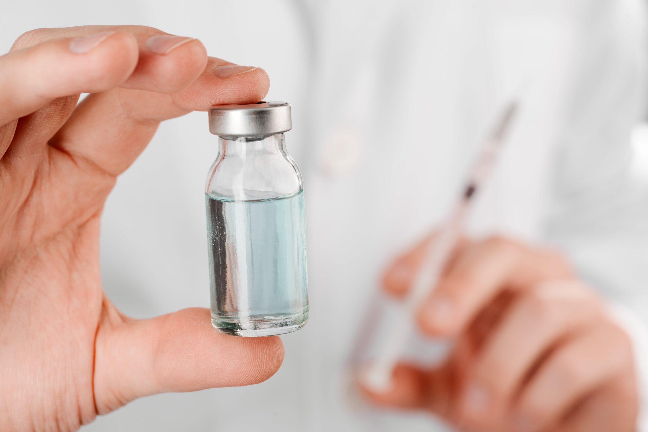 Close-up of hand holding vaccine vial