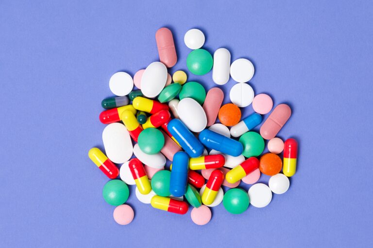 Pile of pills on purple background