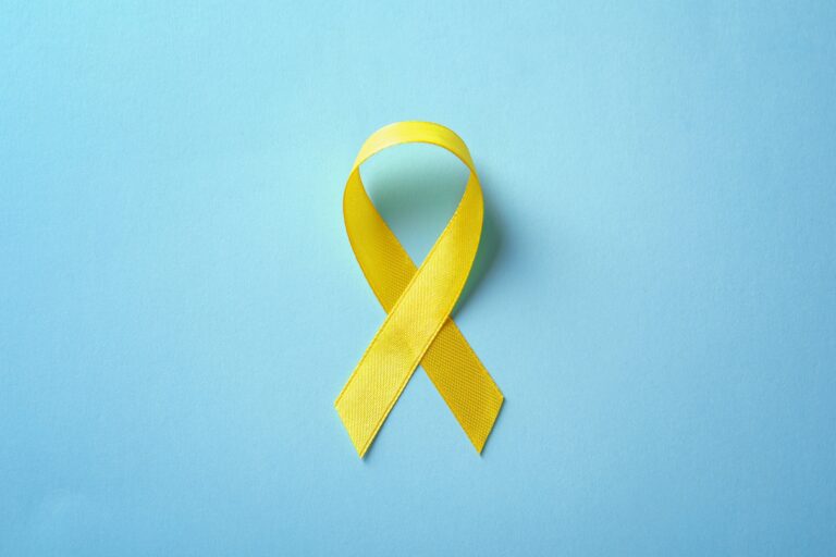 yellow cancer ribbon on blue background