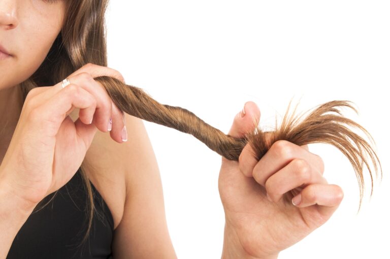 Close-up of woman holding up hair, examining length