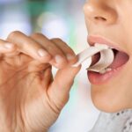 Woman putting chewing gum in her mouth