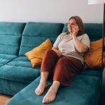 Young woman talking on phone while sitting on couch