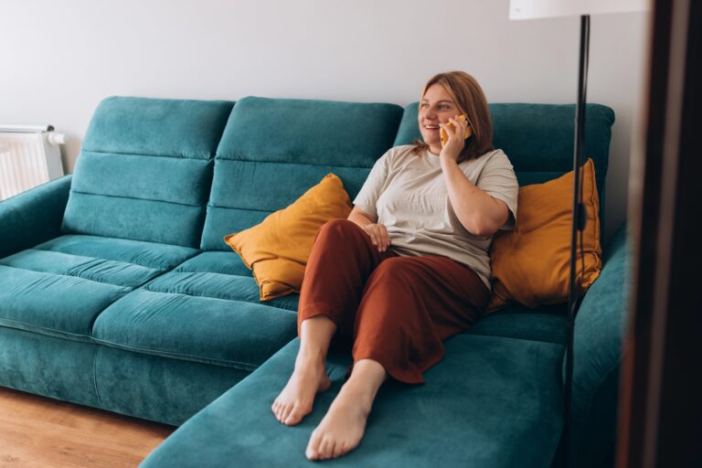 Young woman talking on phone while sitting on couch