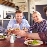 Adult friends toasting and smiling during lunch