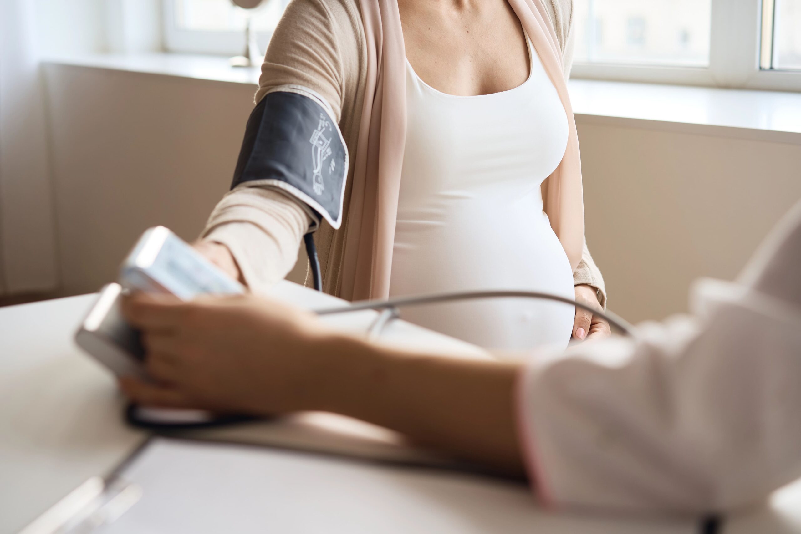 doctor measuring blood pressure of pregnant patient