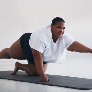Smiling young woman practicing yoga
