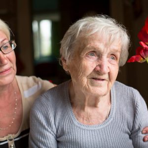 Woman hugging older woman near window