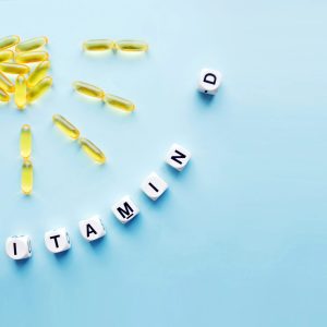 vitamin D pills arranged in shape of sun, blocks spelling vitamin D